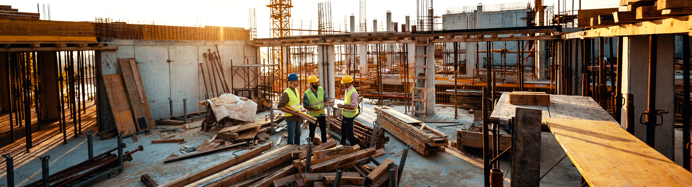 Three men in hard hats on a High Rise Construction site 